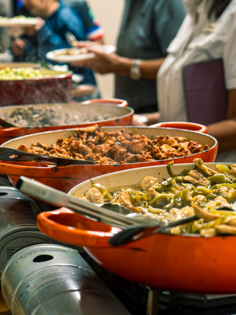 Buffet trays filled with catered Mexican dishes